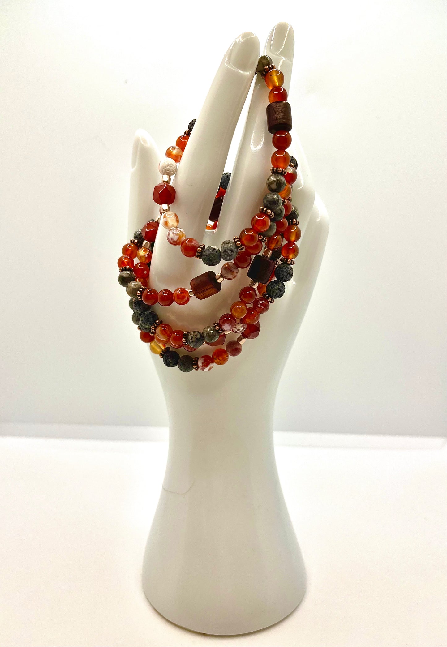 Hand statue with four fire walk with me bracelets draped on it