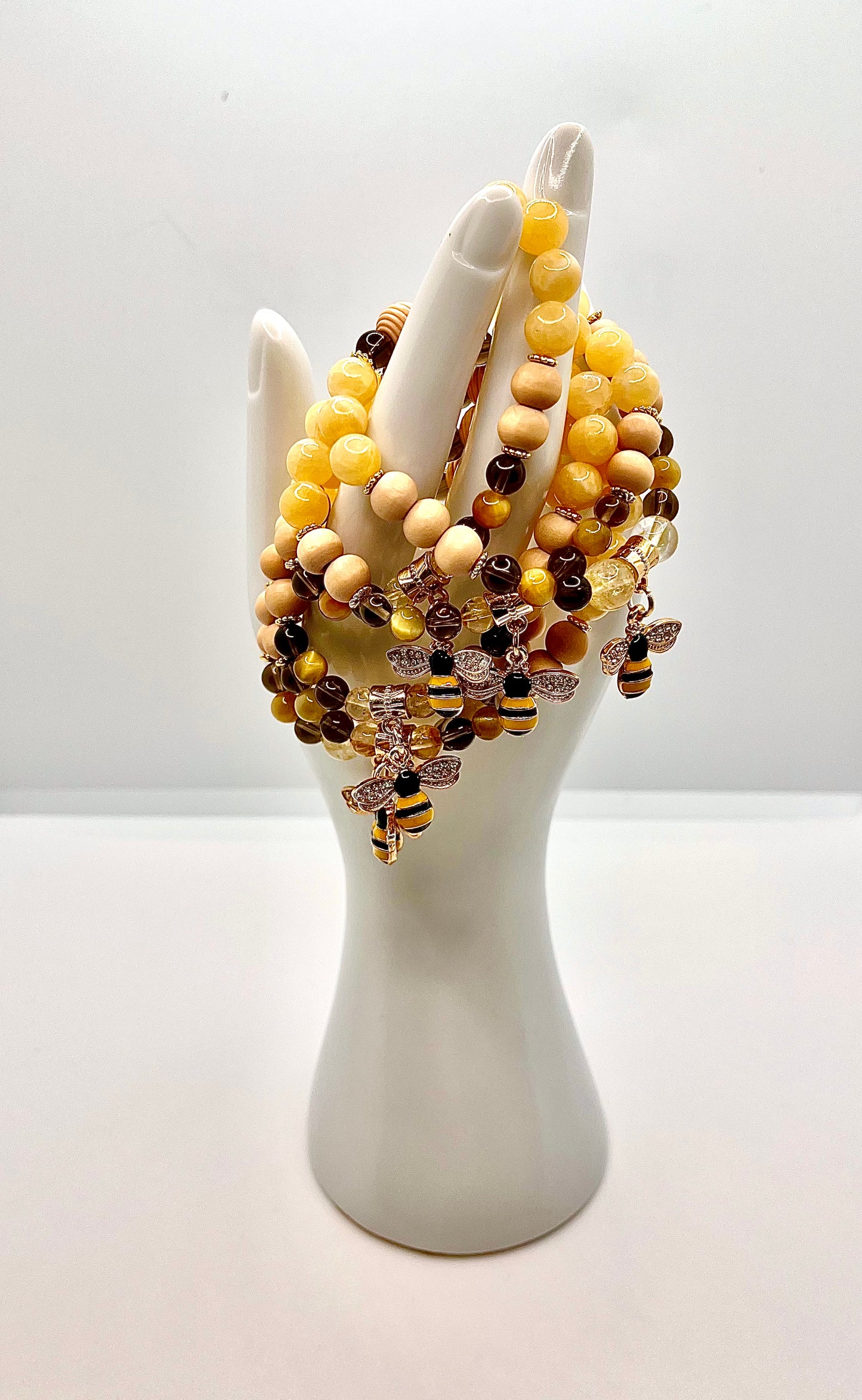 Many lucky b bracelets draped over white hand statue 