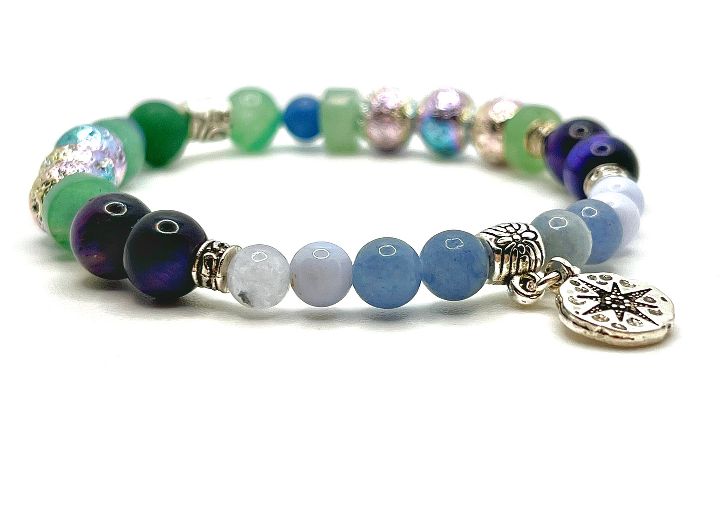 Closeup of Chose your own aventurine bracelet with blue, green, purple and silver beads and flat silver round charm with a compass star on it